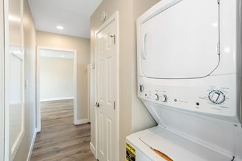a laundry room with a washer and dryer and a hallway with a door